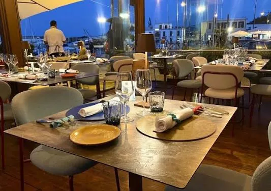 Tavolo apparecchiato nella sala di Riccio Restaurant affacciata sul porto di Baia