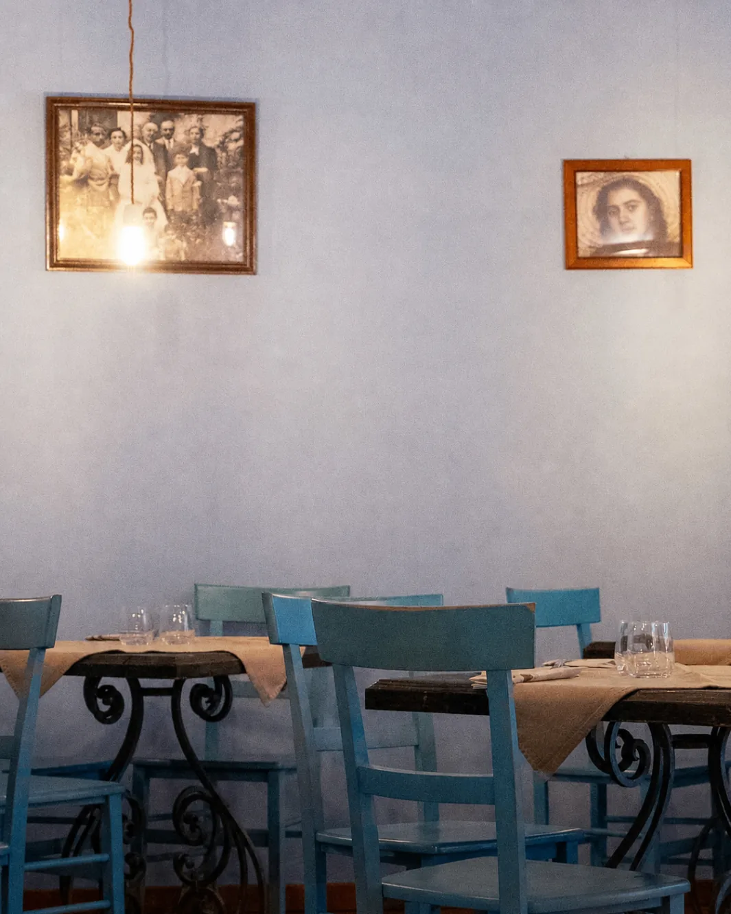 Sala di Biancomangiare con sedie azzurre e foto d'epoca alle pareti